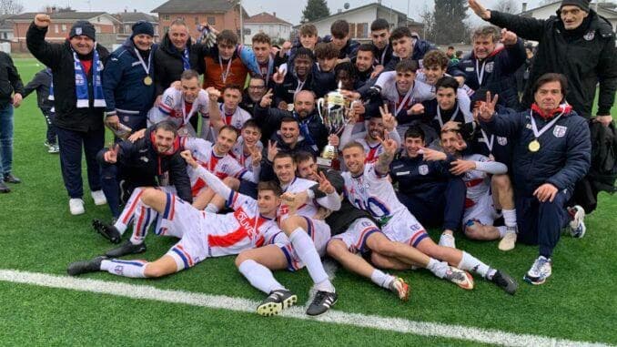 La squadra dell'Alba Calcio posa in campo con la coppa e le medaglie al collo