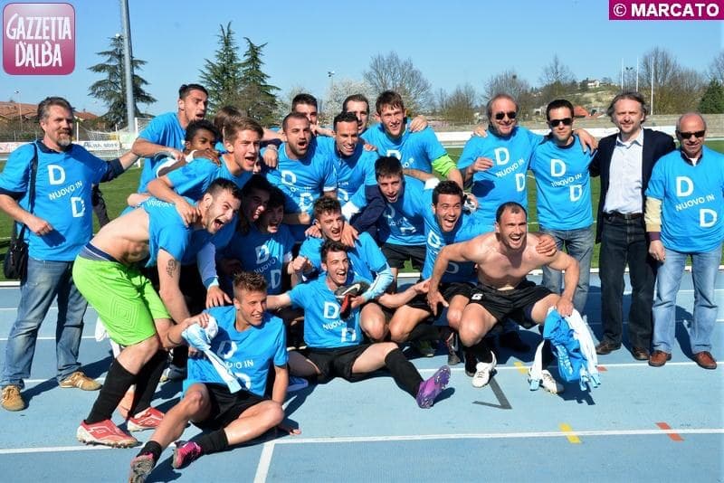I giocatori festeggiano ammucchiati sulla pista d'atletica con le magliette celebrative della promozione in Serie D